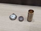 a pocket watch and a lighter sitting on a table