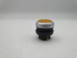 a close up of a small black and yellow button on a white surface
