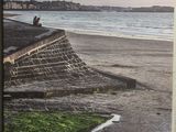 une photo d'un homme assis au bord de la plage
