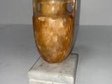 un vase posé sur un bloc de marbre