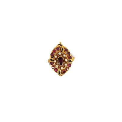 gros plan d'une bague en or avec des pierres rouges et blanches
