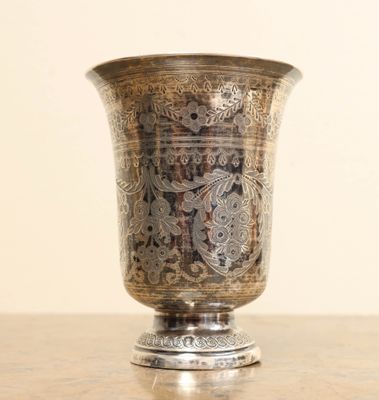 un vase en argent posé sur une table en bois