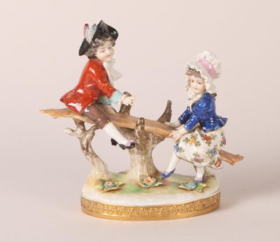 une figurine représentant deux personnes assises sur une branche d'arbre