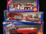 deux camions de pompiers miniatures et un camion miniature dans la boîte