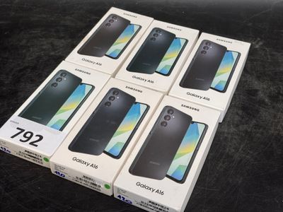 Six boîtes de Samsung Galaxy A9s sont empilées sur une table.