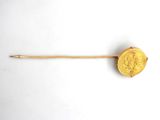 an old gold coin on a wooden stick on a white surface