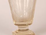 a clear glass cup sitting on top of a glass stand
