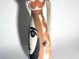 a vase with a face painted on it sitting on a table