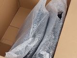 a cardboard box filled with plastic wrap and a pair of shoes in it