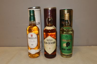 trois bouteilles d'alcool posées les unes à côté des autres sur une table