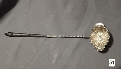 a silver spoon with a flower on it sitting on a table