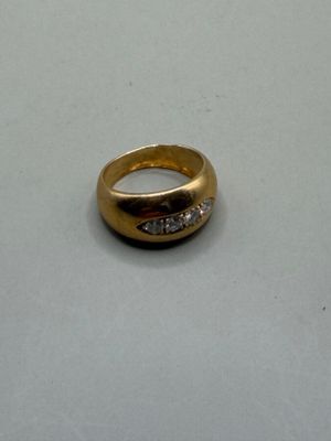 une bague en or sertie de diamants, posée sur un fond blanc