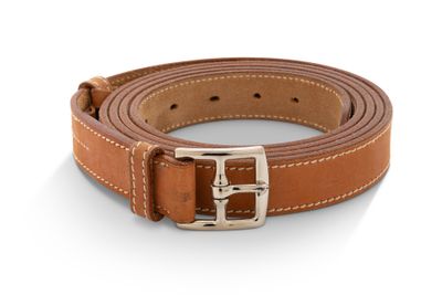 un gros plan sur une ceinture en cuir marron dotée d'une boucle argentée