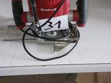 a red and black electric sander sitting on a white table