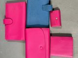 three pink and blue wallets sitting next to each other on a table
