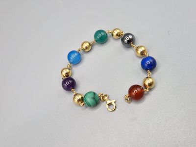 un gros plan sur un bracelet composé de perles de différentes couleurs