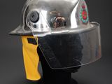 silver helmet on a black stand with a yellow scarf around it
