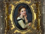 une vieille photo d'une jeune fille dans un cadre doré, posée par terre