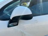 un gros plan sur le rétroviseur latéral d'une voiture, avec le soleil qui brille en arrière-plan