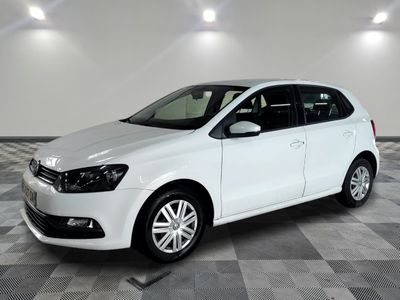 the white volkswagen polo is parked on a checkered tile floor