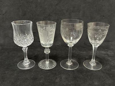 quatre verres à vin sont alignés sur une surface noire