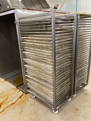 Plusieurs plateaux de nourriture sont empilés les uns sur les autres dans une cuisine