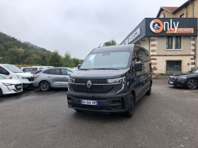 une camionnette noire garée devant un immeuble devant lequel sont garées des voitures