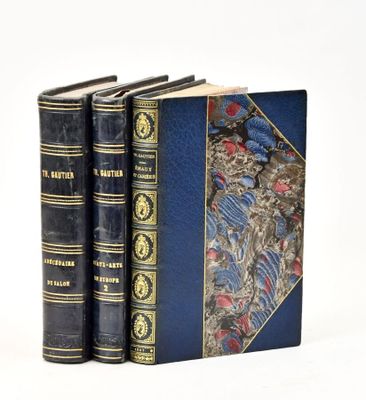 three books are lined up in a row on a white surface