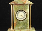 une image représentant une horloge en marbre vert posée sur une table