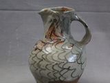 a white and brown vase sitting on a table