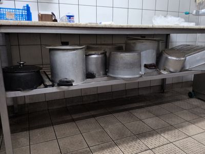many pots and pans sitting on a shelf in a kitchen