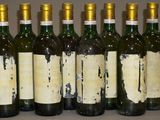six bouteilles de vin sont alignées sur une table