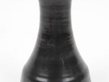 a black vase that is sitting on a white surface