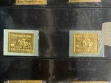 several different types of gold stamps are on display in a glass case