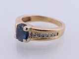 an image of a gold ring with a sapphire stone and diamonds