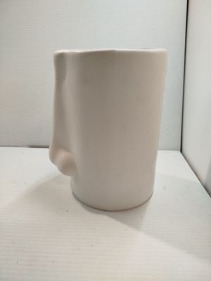 une tasse à café blanche posée sur une table blanche