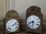 two clocks that are sitting next to each other on the floor