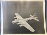 black and white photo of an old airplane flying in the sky