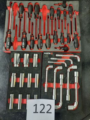 les nombreux outils qui se trouvent dans le bac posé sur la table