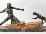 two bronze statues of a man and a dog on a marble base