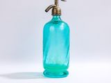 une bouteille en verre bleue munie d'un robinet en laiton