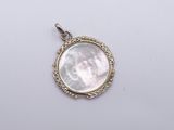 a white mother of pearl pendant on a white background