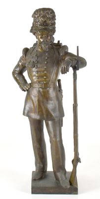 statue en bronze représentant un homme en uniforme tenant un fusil et une carabine