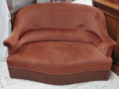 un canapé marron posé sur un tapis blanc