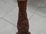 a vase that is sitting on the floor next to a plaque