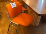 many orange chairs in a room with a wooden table