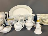 many white dishes and cups and saucers on the table