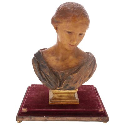 buste en marbre représentant une femme, posé sur un socle en velours rouge