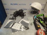 the contents of a helmet, gloves, and other items are on a table