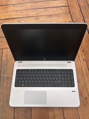 un ordinateur portable ouvert posé sur un parquet